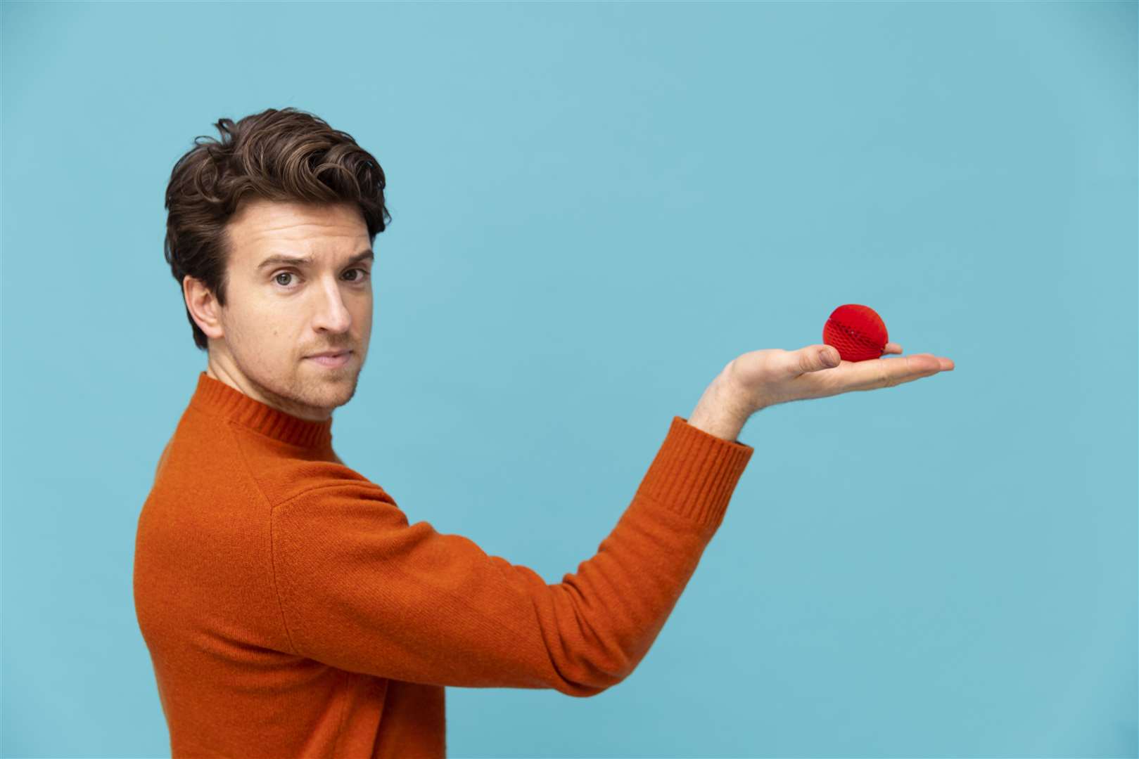 Radio Presenter Greg James shows the new red nose that is primarily made of paper. Image: Comic Relief.